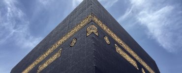 Upward view of corner of the Ka'abah against a blue sky